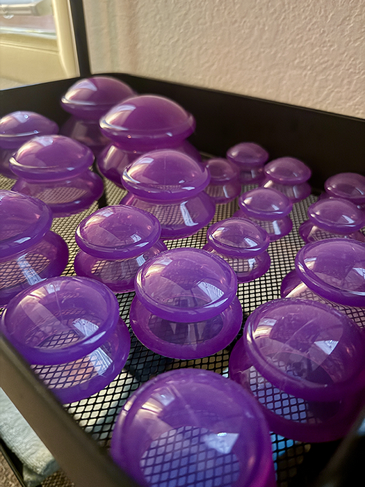 Purple silicone massage cups in multiple sizes are arranged on a tray at HazMatt Holistic Healing in Flagstaff, Arizona. These cups are used during silicone cupping therapy to help relieve muscle tension, improve mobility, increase local circulation, and complement therapeutic massage sessions.