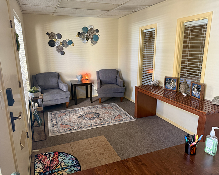 The lobby at HazMatt Holistic Healing in Flagstaff features a welcoming front desk, warm lighting, Buddha statues, natural stone décor, and a peaceful environment where clients check in before their massage session.