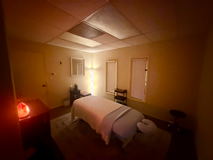 A peaceful massage therapy room at HazMatt Holistic Healing in Flagstaff featuring a comfortable massage table, soft lighting, a Himalayan salt lamp, massage supplies, and a relaxing environment for personalized bodywork sessions.